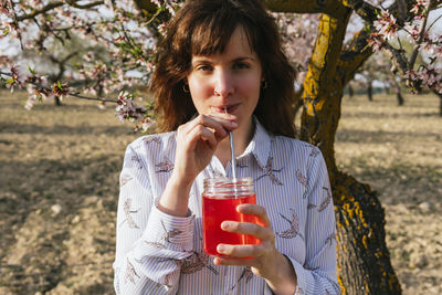 Portrait of young woman drinking glass