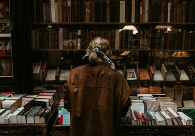 Rear view of woman standing in library