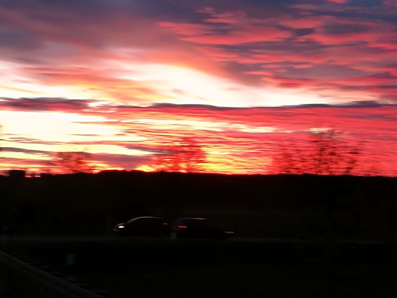 CARS ON ROAD AGAINST SKY DURING SUNSET