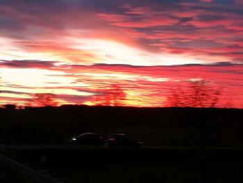 Scenic view of silhouette landscape against orange sky