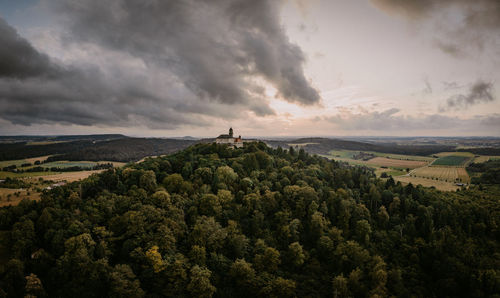 Rear view of man standing on mountain against sky