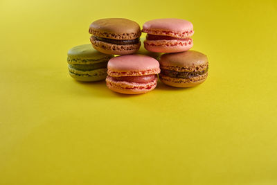 Close-up of multi colored candies against yellow background