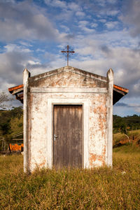 Exterior of old building on field against sky