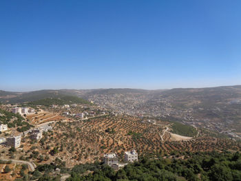 Aerial view of townscape against clear blue sky