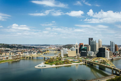 River amidst buildings in city against sky