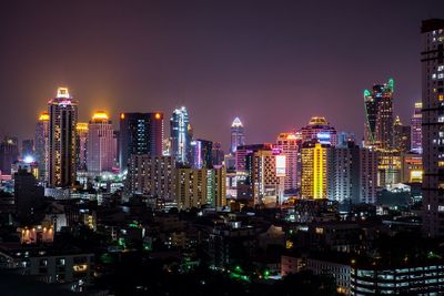 Illuminated cityscape against sky at night