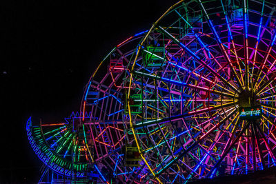 Low angle view of illuminated ferris wheel at night