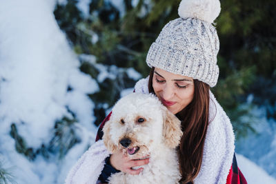 Woman with dog in snow during winter