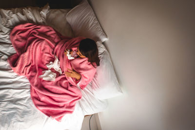 High angle view of woman sleeping on bed at home