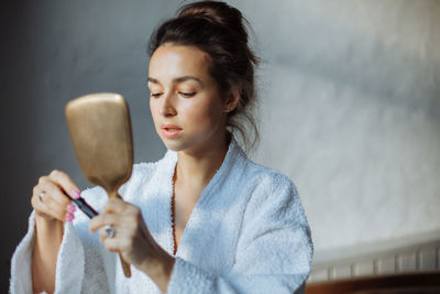 Brunette woman paints eyelashes with black mascara