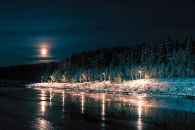 Scenic view of lake against sky at night