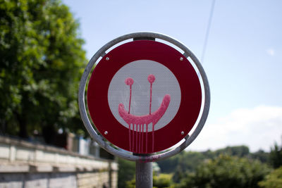 Close-up of road sign against sky