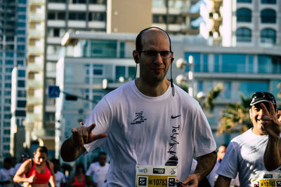 Man with arms raised standing in city