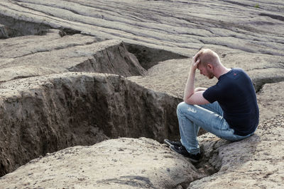 Side view of woman sitting on rock