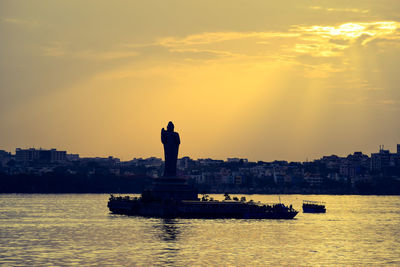 Silhouette of boat in sea during sunset