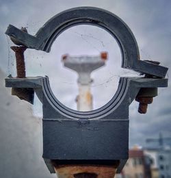 Close-up of rusty metallic structure against sky