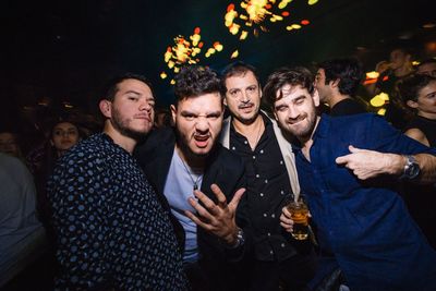 Young man and smiling friends at night