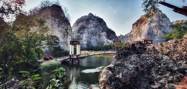 Panoramic shot of rocks by river against sky