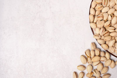 Pistachios on the plate on light background with copy space. tasty pistachios on the table