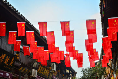 Low angle view of flags hanging against clear sky