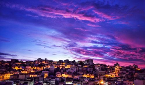 Aerial view of illuminated city against sky at sunset