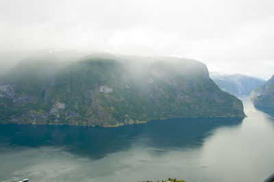 Scenic view of lake by mountains against sky