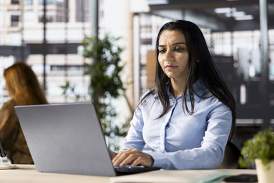 Young woman using laptop at office