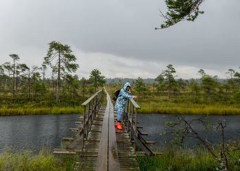 Rear view of woman walking on boardwalk