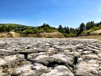 Surface level of rocks against clear blue sky