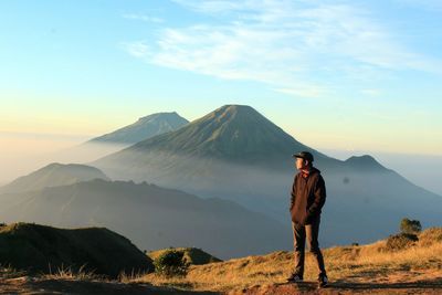 Man standing on mountain against sky