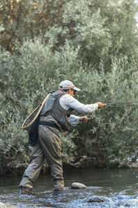 Man fishing in lake at forest