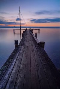 Pier over sea against sky during sunset