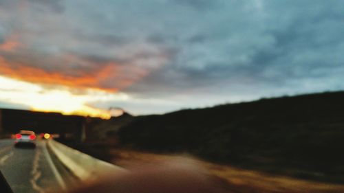 Close-up of car on road against storm clouds