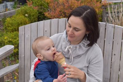 Cute baby boy holding mother and daughter outdoors