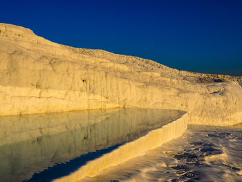 Scenic view of desert against blue sky