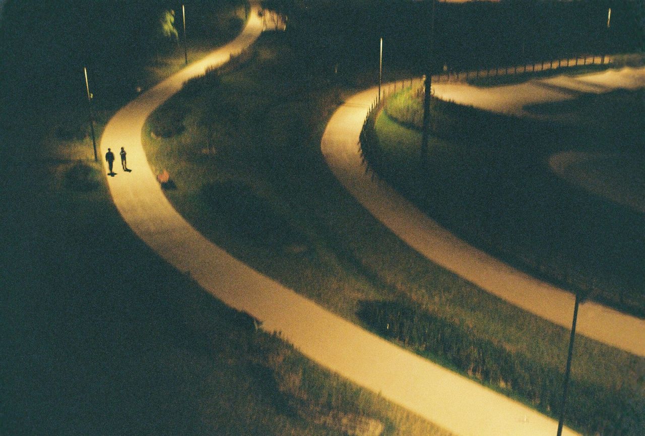 high angle view, transportation, road, night, illuminated, road marking, shadow, the way forward, street, built structure, outdoors, sunlight, architecture, curve, street light, no people, incidental people, unrecognizable person, travel, auto post production filter