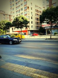 Cars on street by buildings in city