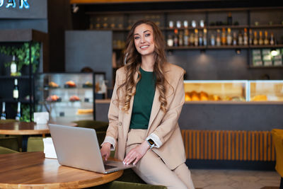 Portrait of young woman using laptop on table