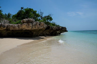 Scenic view of sea by rock formation against sky