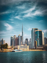 Modern buildings in city against cloudy sky
