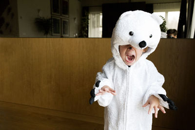 Boy wearing polar bear costume at home