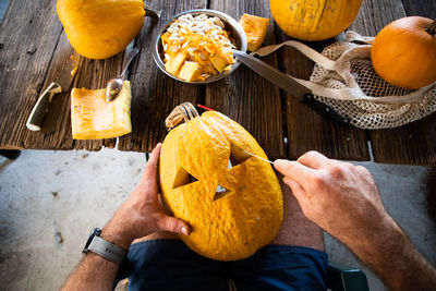 Midsection of man with pumpkin