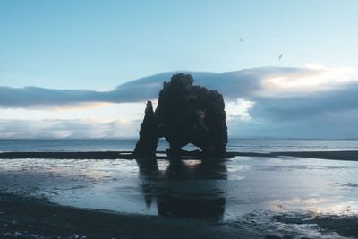 Silhouette man standing on beach against sky during sunset