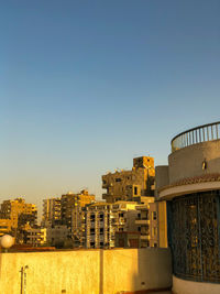 Buildings in city against clear sky