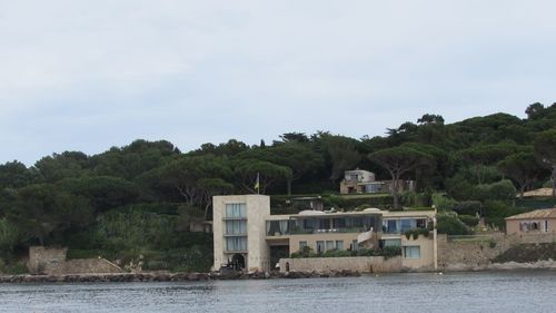 Houses by sea against sky