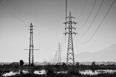 Low angle view of electricity pylon against clear sky