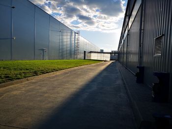 Empty road amidst buildings against sky