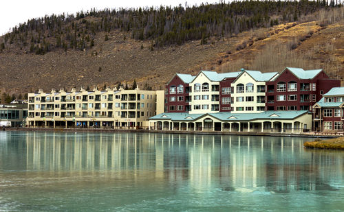Houses by lake against sky