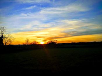 Scenic view of silhouette field against sky during sunset