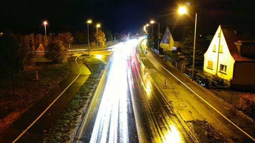 Illuminated light trails on road in city at night